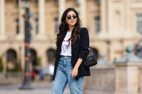 A woman wearing jeans with a t-shirt and blazer