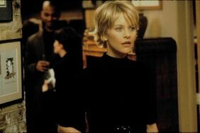 Meg Ryan wearing a black belted dress in You've Got Mail