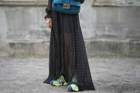 A woman wears green sneakers with a long maxi dress.