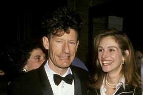 Lyle Lovett in a tux alongside Julia Roberts in a striped suit