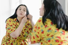 Woman putting on earrings 