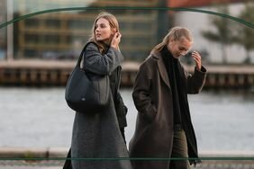 Two people walking along a river wearing Dark Academia fashion